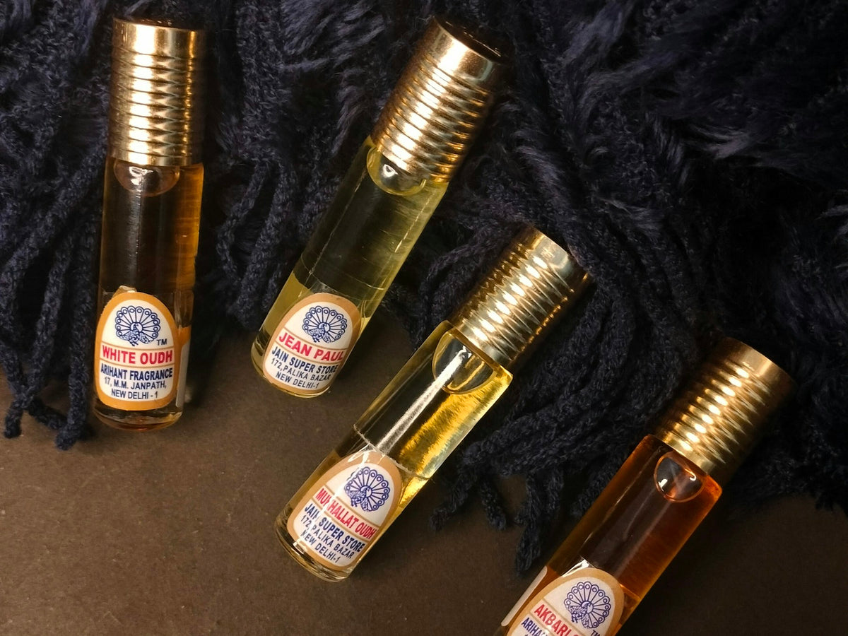 Afnan perfumes — gold-capped concentrated perfume oil vials arranged on black fabric